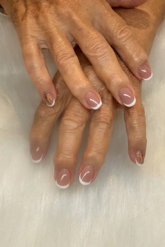 white french tips on sheer pink base, medium oval, crossed hands