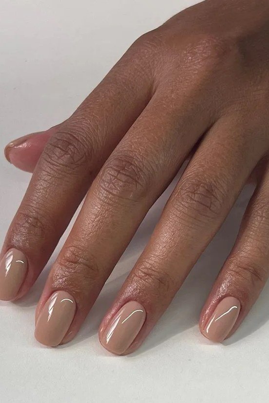 Glossy caramel nude almond nails on deep skin - caramel nude nail idea for women over 50