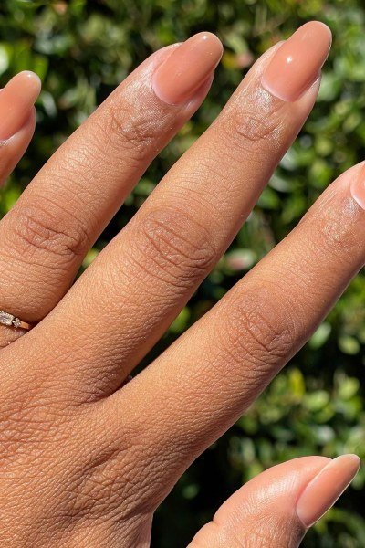 Warm caramel nude almond nails in outdoor sunlight - caramel nude nail idea for women over 50