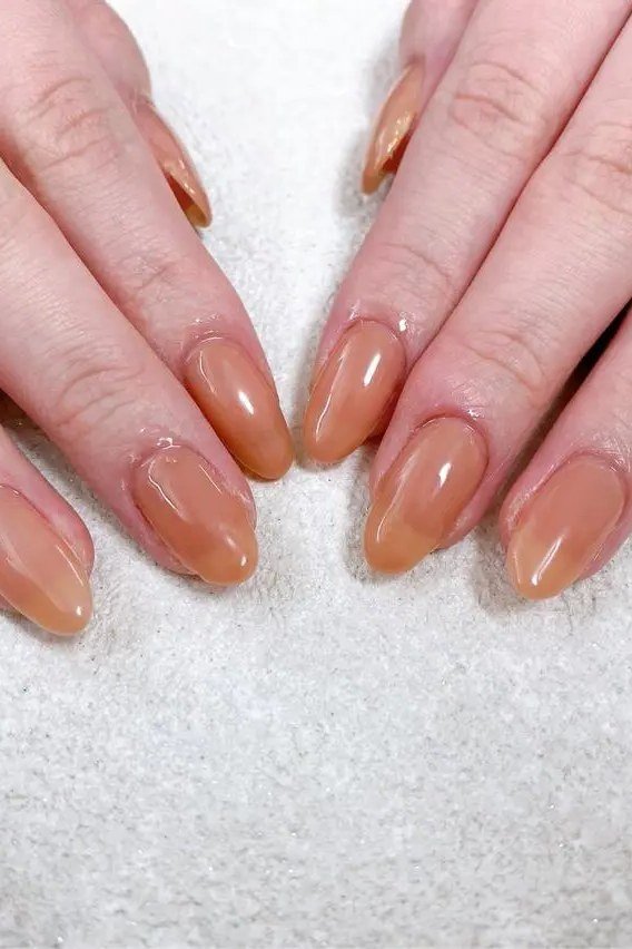 Warm caramel almond nails on both hands - caramel nude nail idea for women over 50