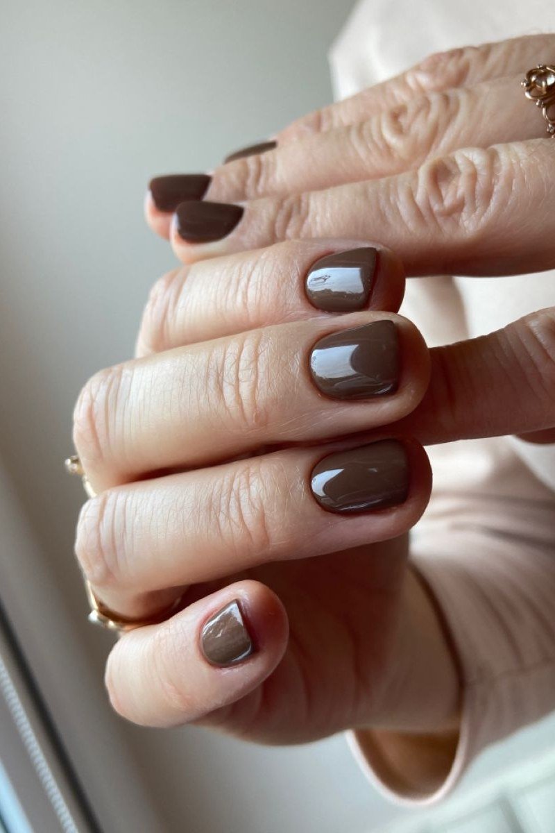 Mocha taupe squoval nails on mature hands - caramel nude nail idea for women over 50