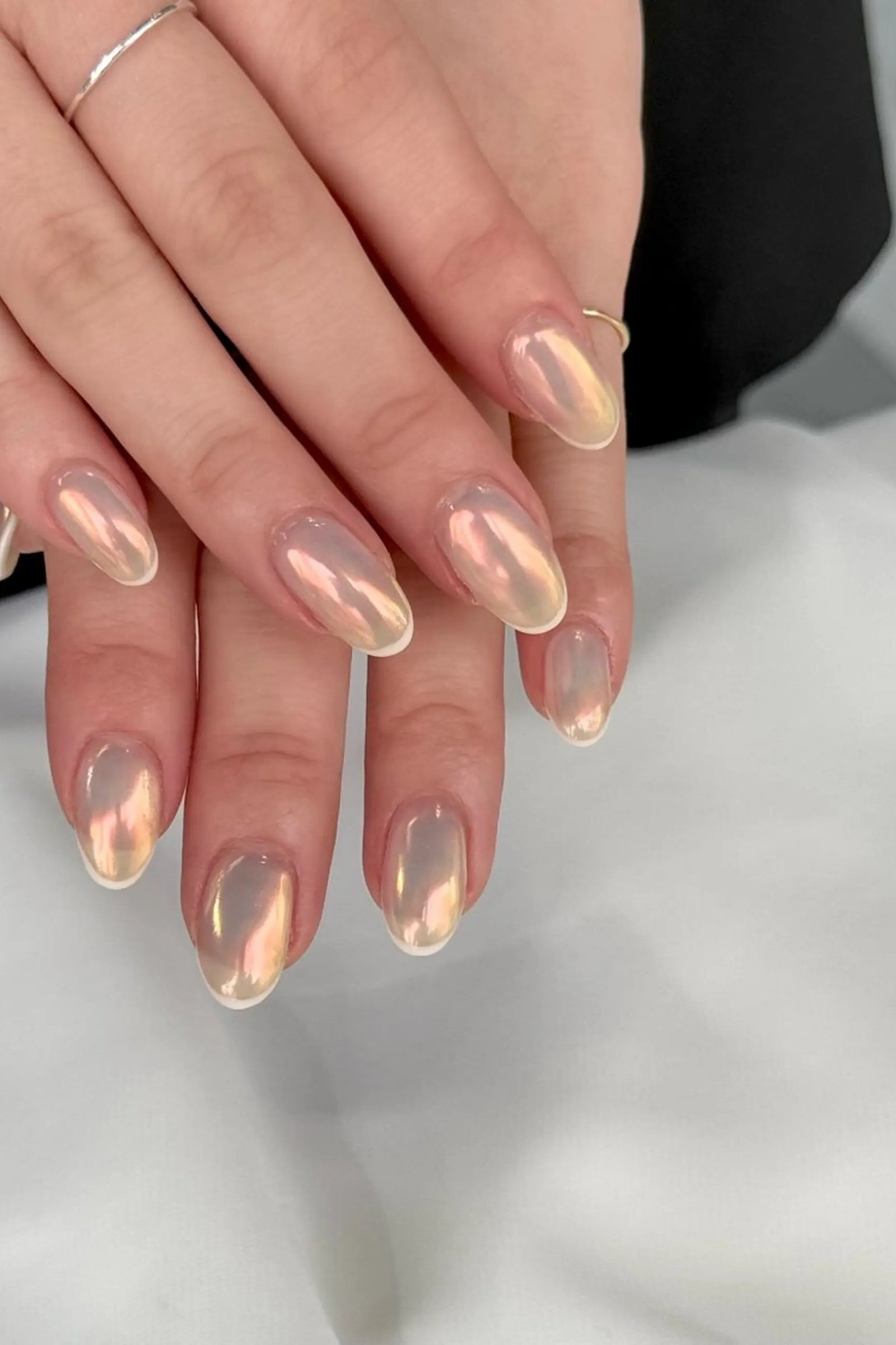 Pearl chrome almond nails with golden shimmer tips for women over 50