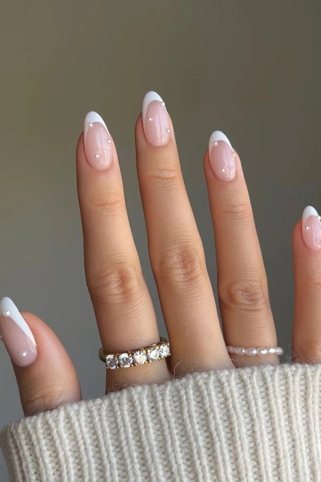 Pearl french nails styled with delicate rings for women over 50