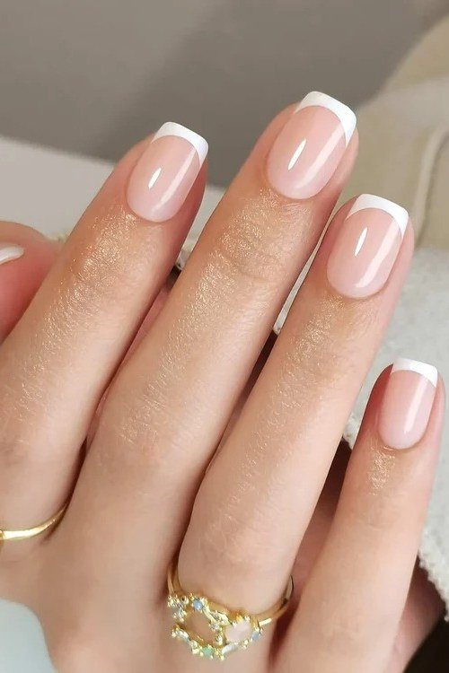 Short square french tip with gold rings - flattering nail idea for women over 50