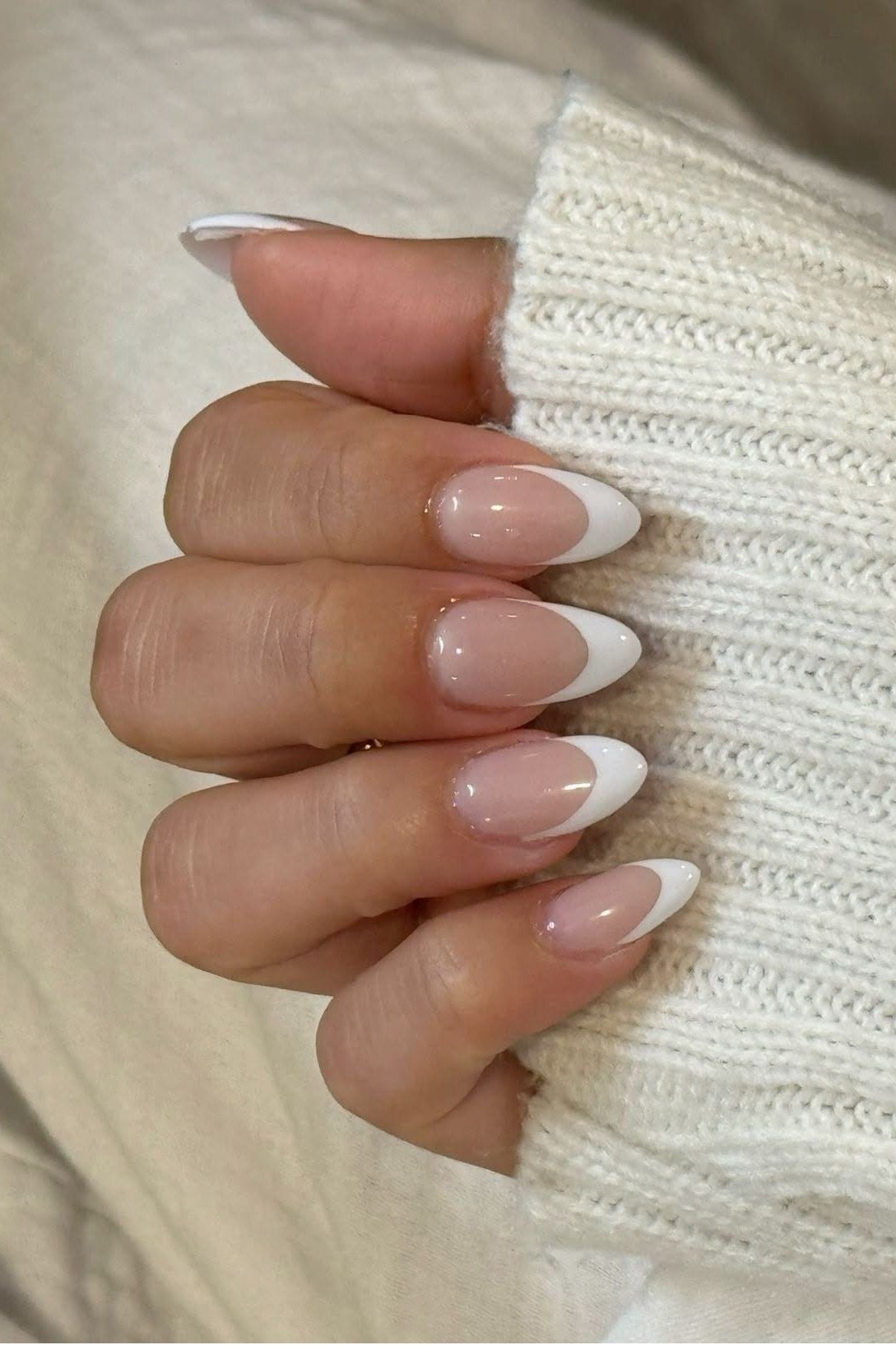 Short almond french tip, knit sleeve - flattering nail idea for women over 50