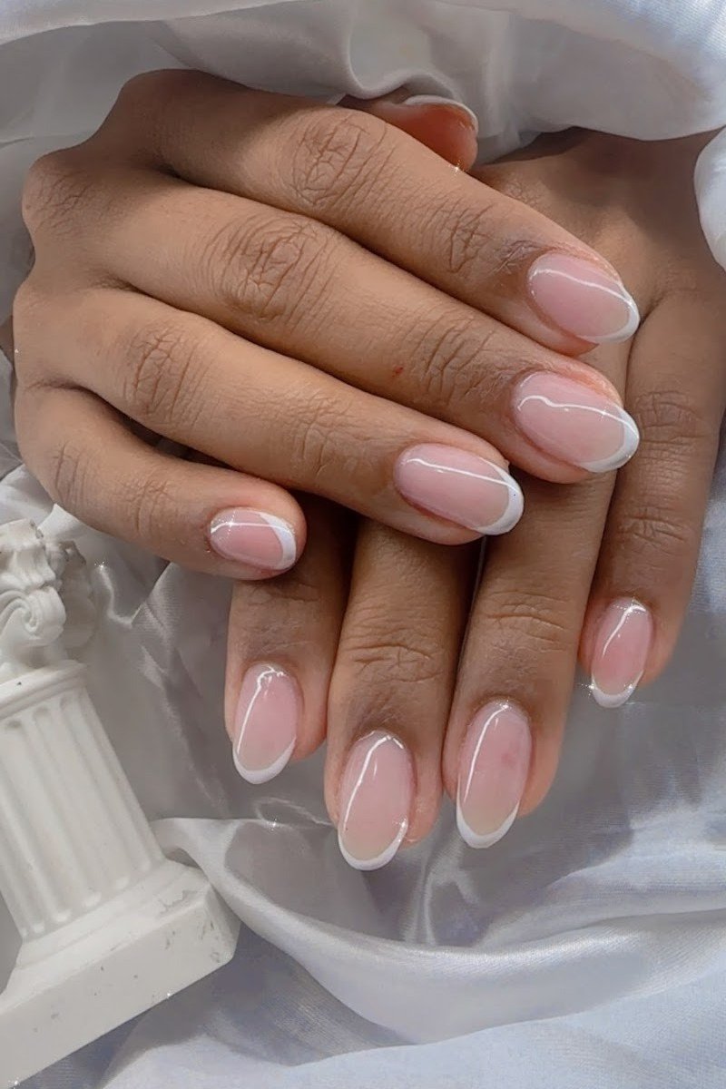 Short pink french tip, sweater - flattering nail idea for women over 50