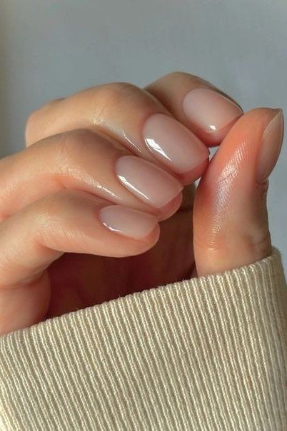 Glossy nude oval, sweater cuff - flattering nail idea for women over 50