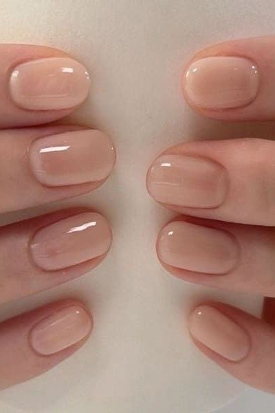 Glossy nude short nails, both hands - flattering nail idea for women over 50