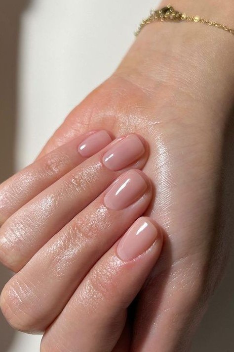 Pale pink oval with gold bracelet - flattering nail idea for women over 50