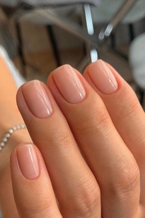 Glossy nude almond with pearl bracelet - flattering nail idea for women over 50