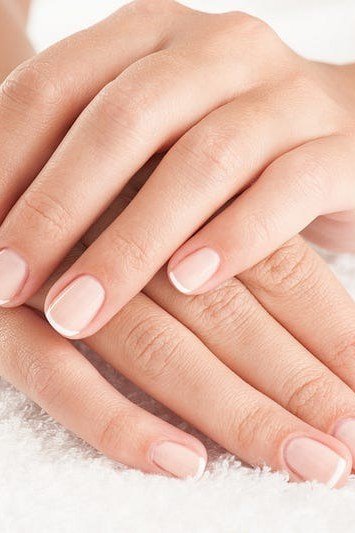 Soft pink nude, folded mature hands - flattering nail idea for women over 50