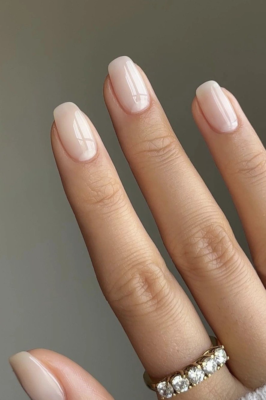 Long oval pearly white nude nails with ring for women over 50