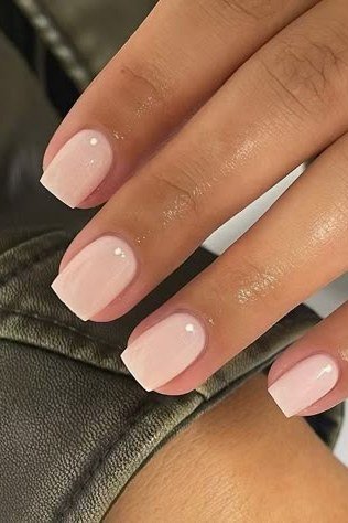 Squoval milky pink nails on dark background for women over 50