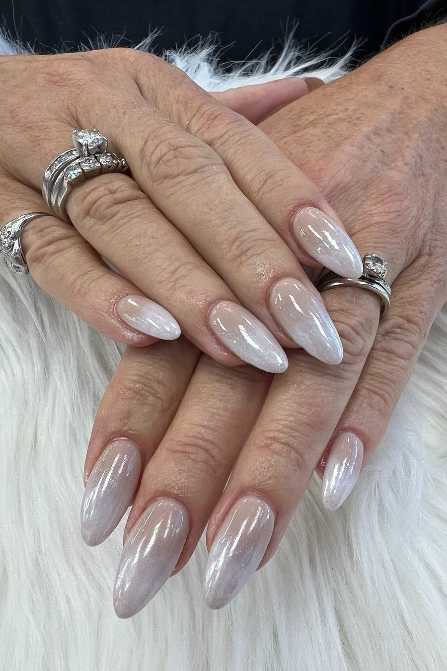 Almond gray nude nails on mature hands with rings for women over 50