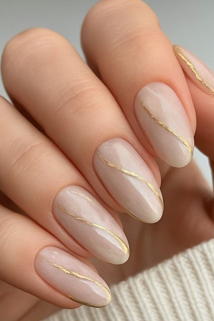 Almond nude nails with delicate gold line art for women over 50