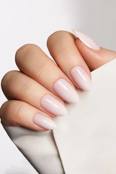 Short oval milky white nails on white fabric for women over 50