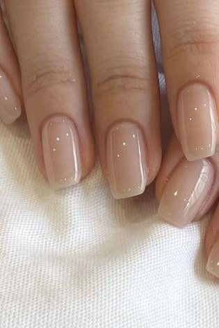 Squoval sheer beige nude nails glossy close-up for women over 50