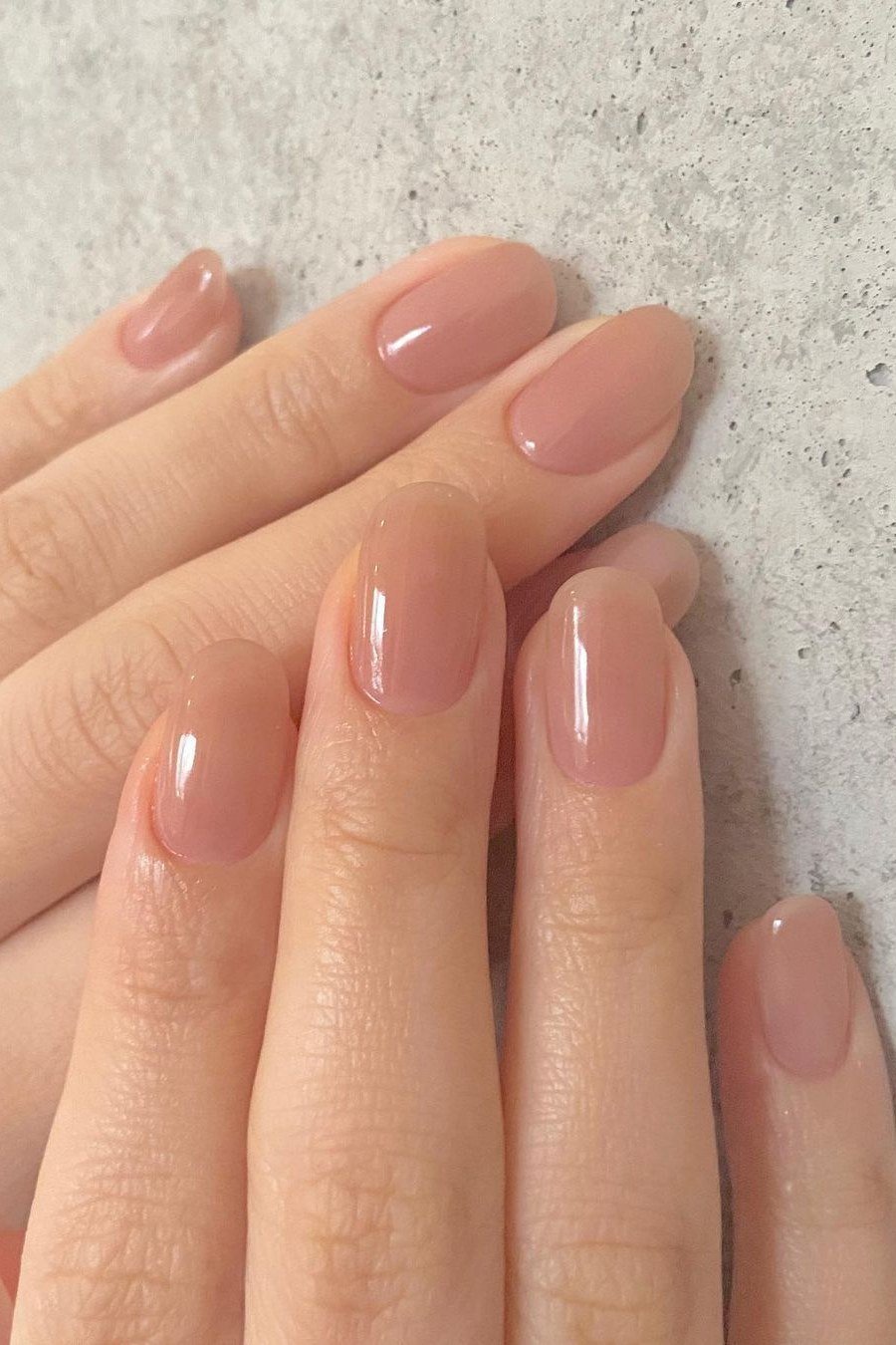 Short round pale pink nails glossy two hands for women over 50