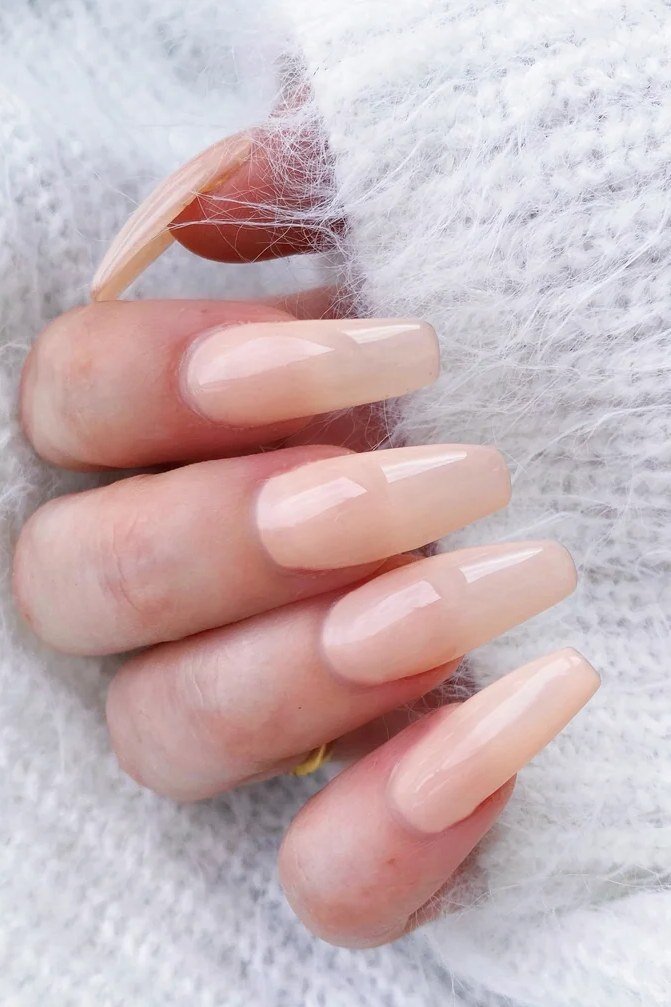 Medium almond sheer nude nails with white sweater for women over 50
