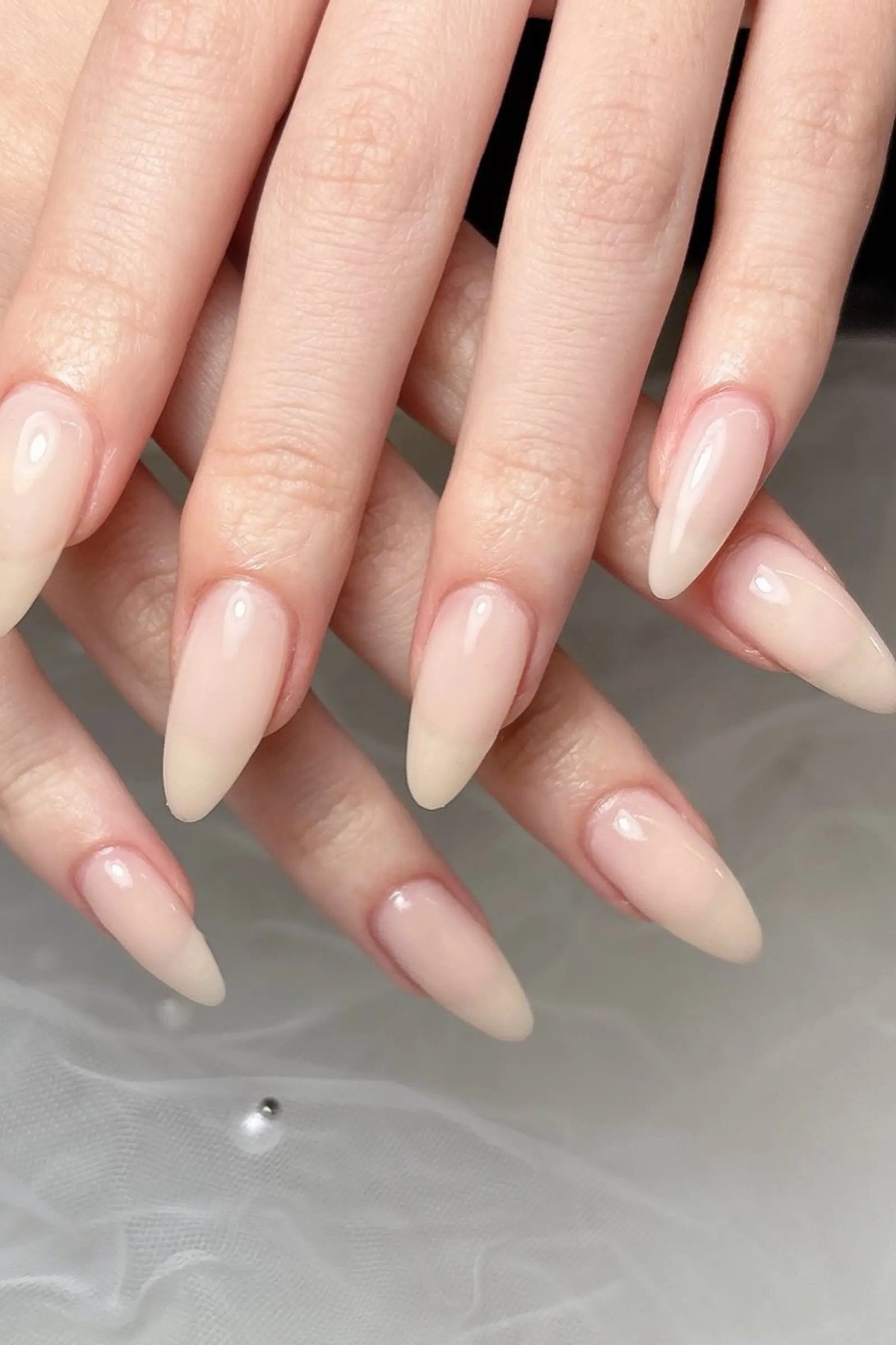 Long almond nude nails glossy front view for women over 50