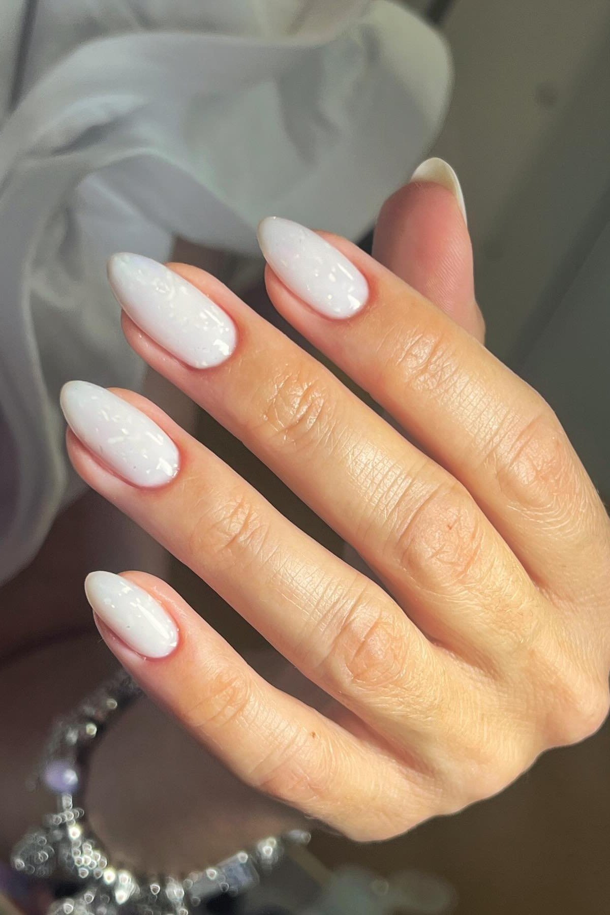 Medium almond milky white nails side view for women over 50