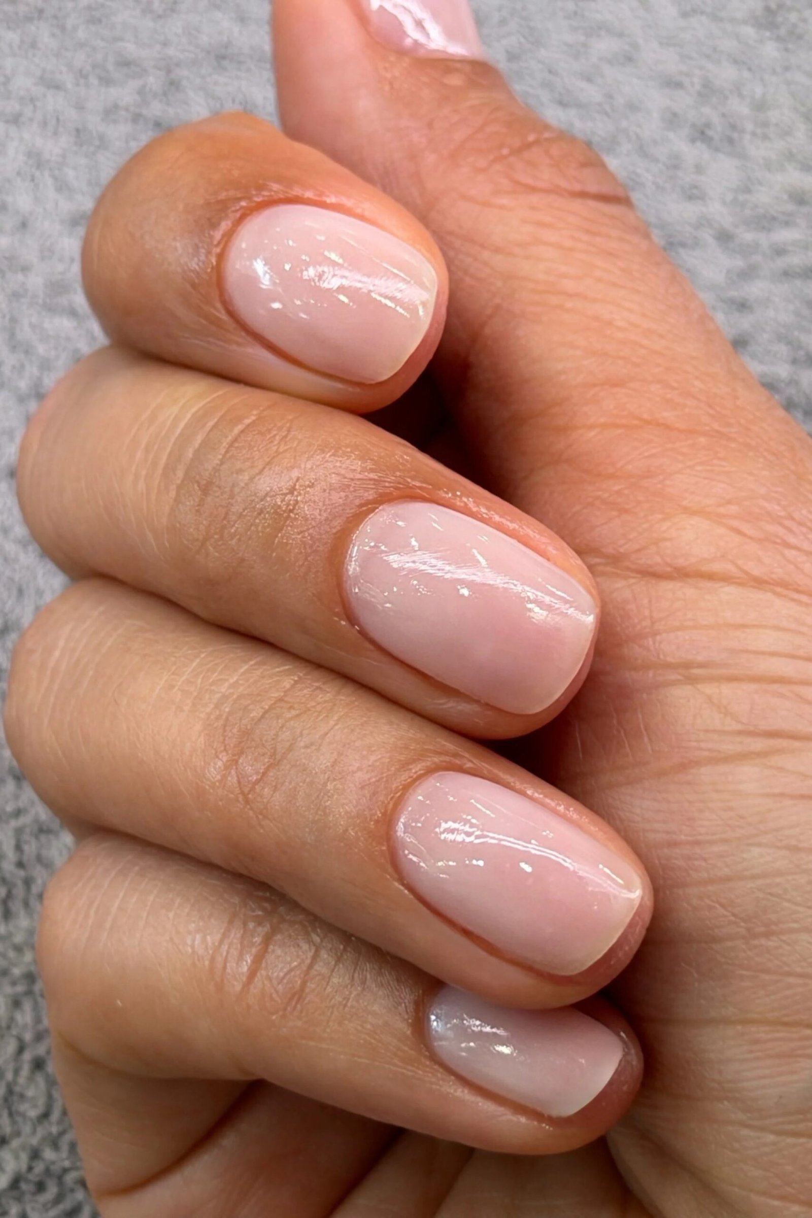 Clasped hands with milky nude nails side view for women over 50