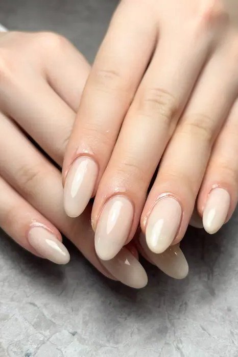 Milky white almond nails both hands front view for women over 50
