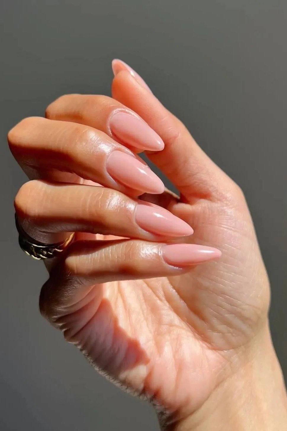 Almond pink nude nails on dark background dramatic for women over 50