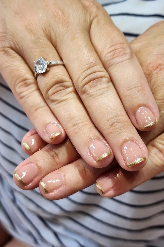 Nude with gold french tips, mature hands - nail art for women over 50