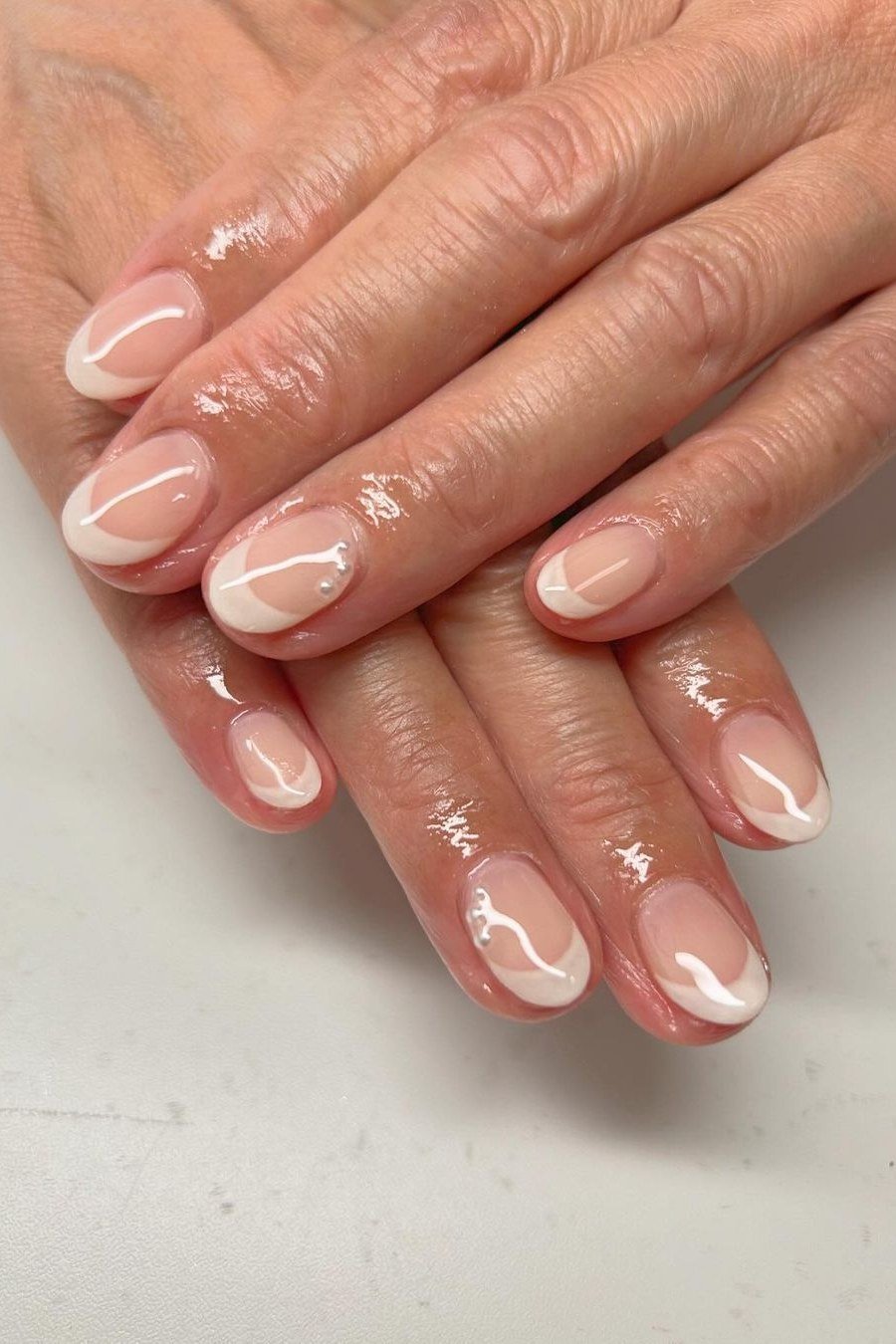 Nude french with thin gold line, mature hands - nail art for women over 50