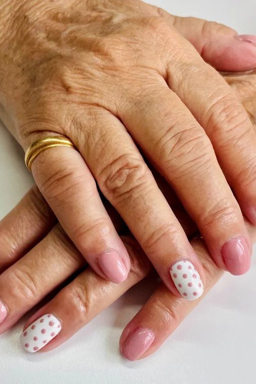 Pink with white polka dot art, mature hands - nail art for women over 50