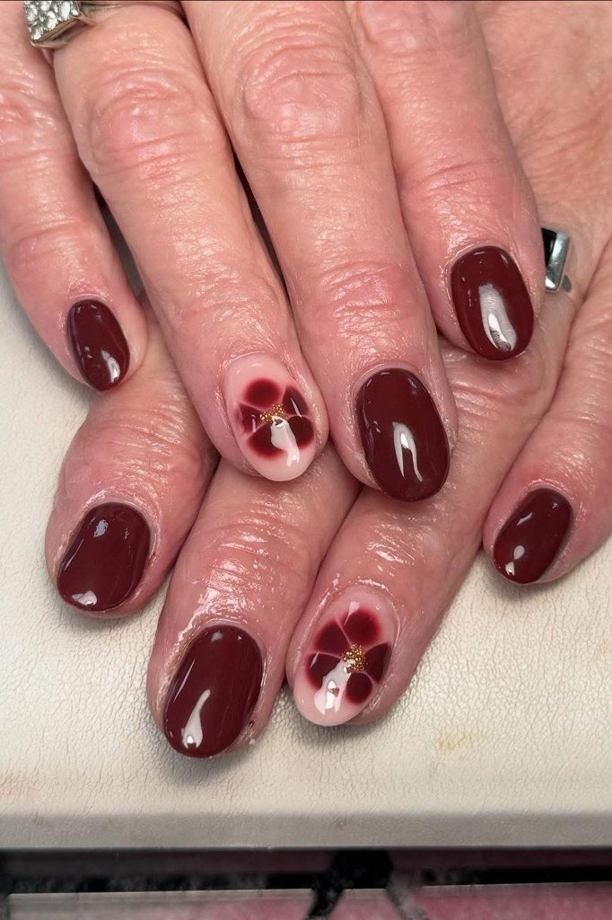 Burgundy with wine-tone floral art, mature hands - nail art for women over 50