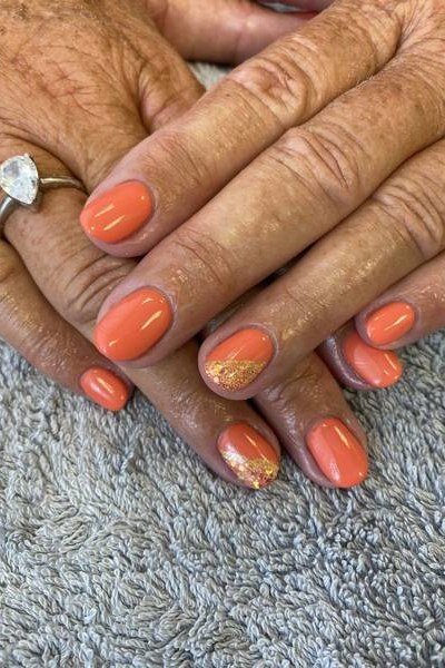 Coral with gold glitter accents - nail art for women over 50