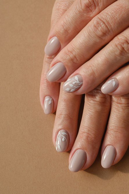 Taupe grey with white leaf line art, mature hands - nail art for women over 50