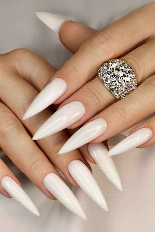 Long white stiletto nails with crystal statement ring
