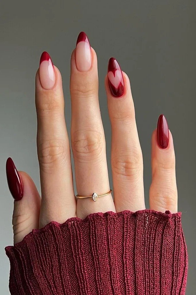 Red french tips on almond nails with a red heart art accent, glossy