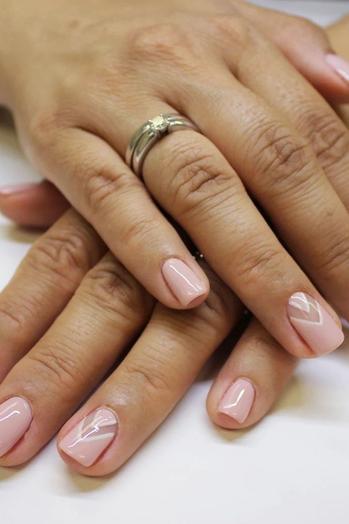White chevron french tips on nude almond nails, mature hands