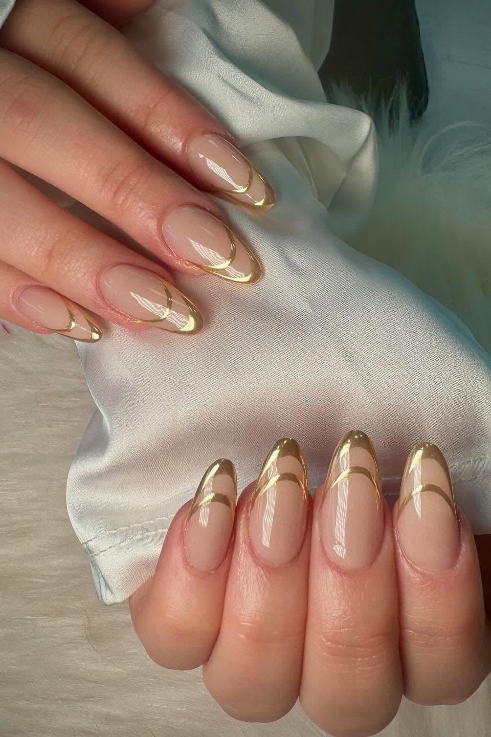 Nude almond nails with gold chrome french tips