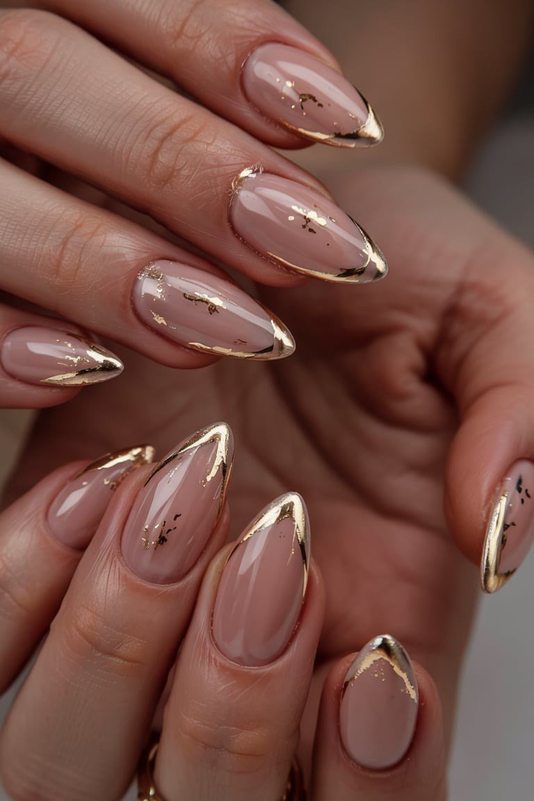 Nude almond nails with gold geometric line tips