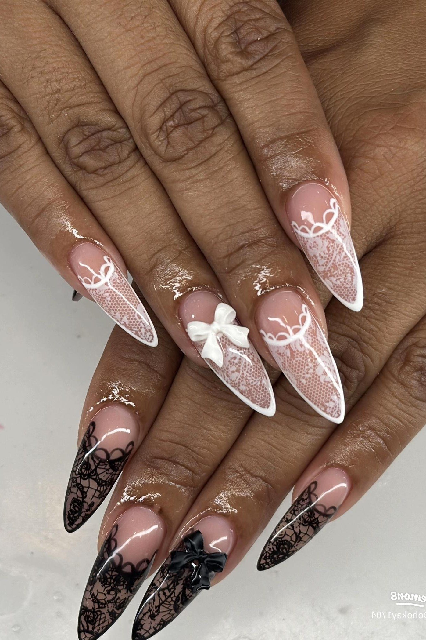 Black lace art stiletto nails on dark-skinned hands