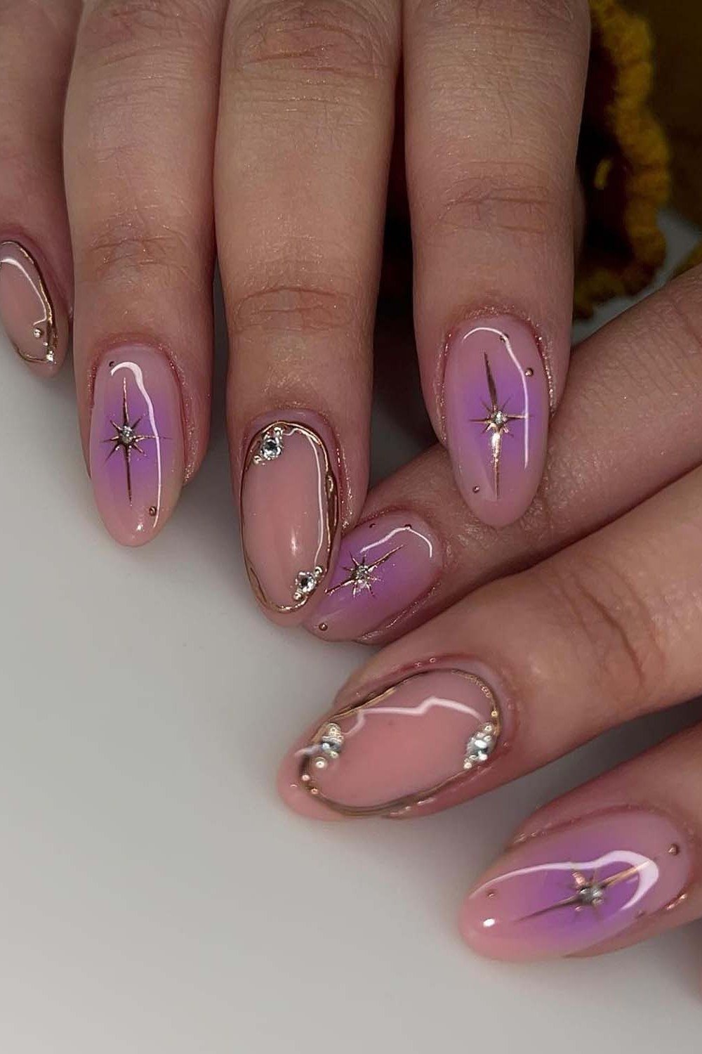 Purple oval nails with gold art accents