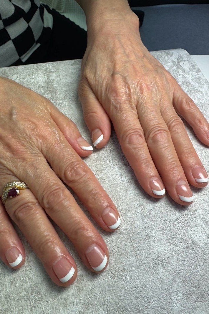 Bright white French tips on mature hands over 50