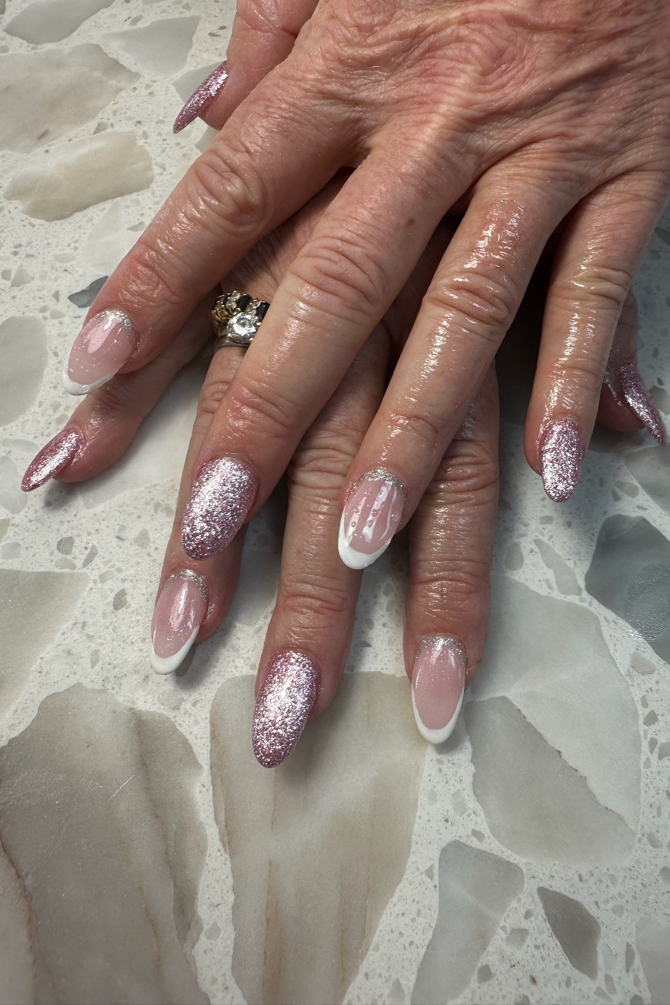 Rose-gold glitter French tips on mature hands for women over 50