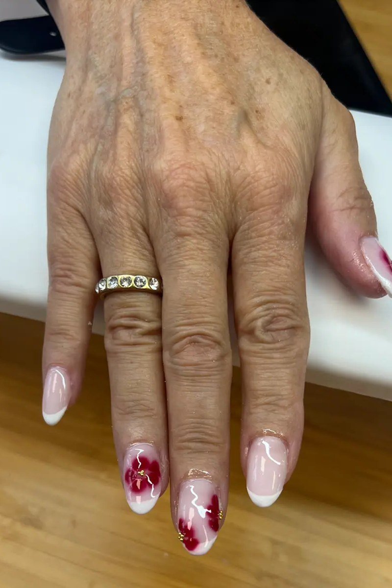 French tips with red floral nail art for women over 50
