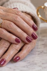 Rich berry short nails for women over 70 on mature hands