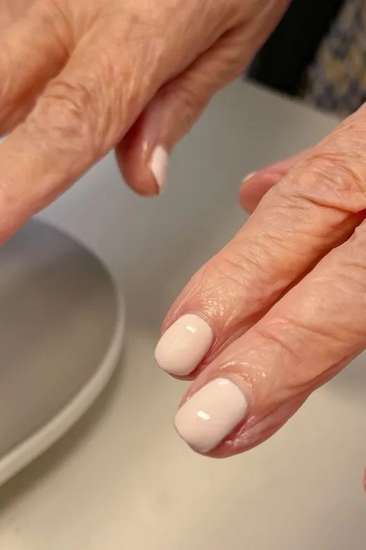 Crisp white short nails for women over 70 on older hands