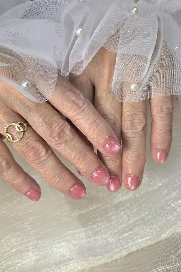 Soft pink ombre nails for women over 70 on older hands