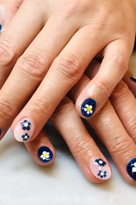 Navy blue nails with daisy nail art for women over 70