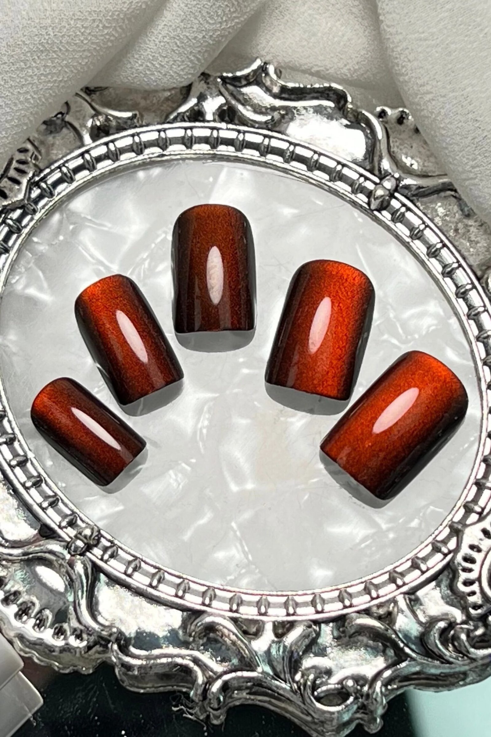 Amber tortoise jelly nails on silver tray, short square - jelly nail idea for women over 60