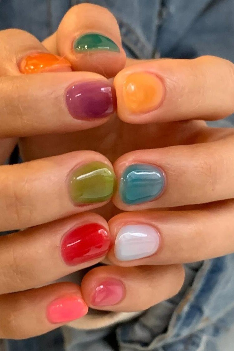 Multicolor jelly nails on older hands, blue green orange red - jelly nail idea for women over 60